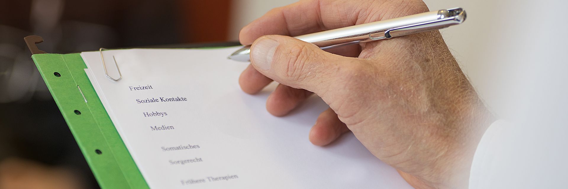 Eine Hand hält einen Stift und notiert etwas