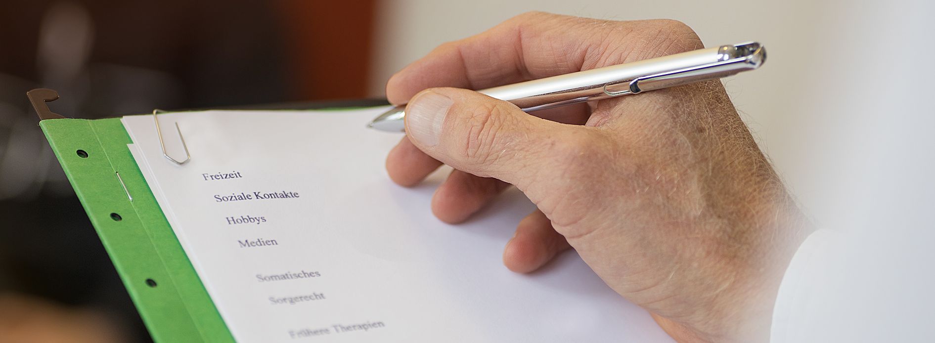 Eine Hand hält einen Stift und notiert etwas